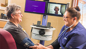 Mujer con una enfermera y el médico en videoconferencia