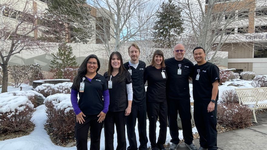 A team of infection preventionists pose outside in a garden for a group photo.