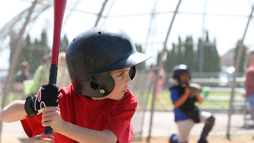 kid with red shirt playing baseball