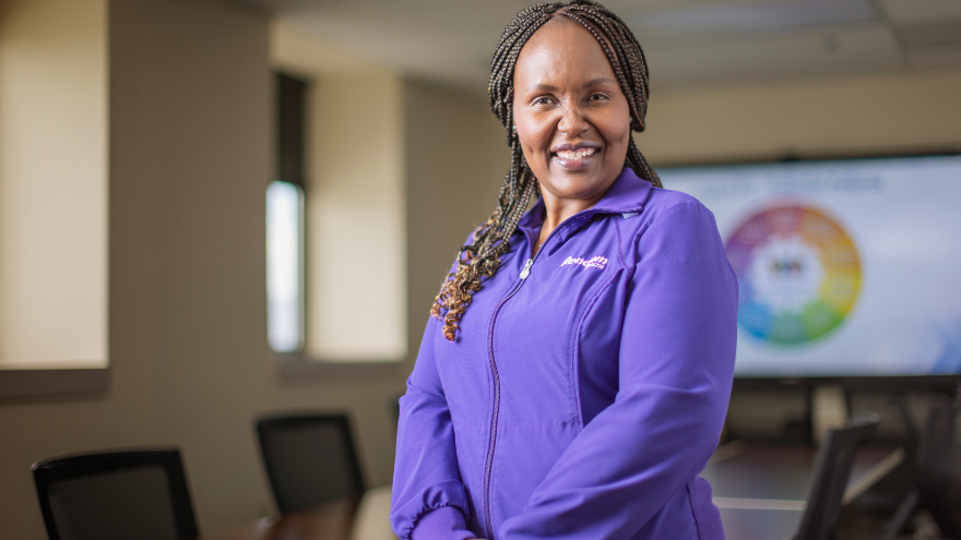 Poeth Kilonzo, Director of Nursing Oncology, poses for a photo while smiling in a conference room.