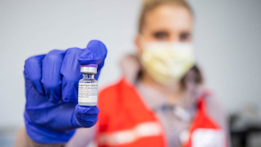 Pharmacist holding COVID vaccine vial
