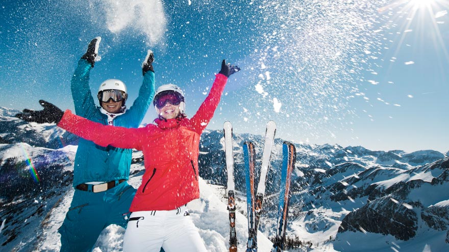 Couple skiing and posing in snow