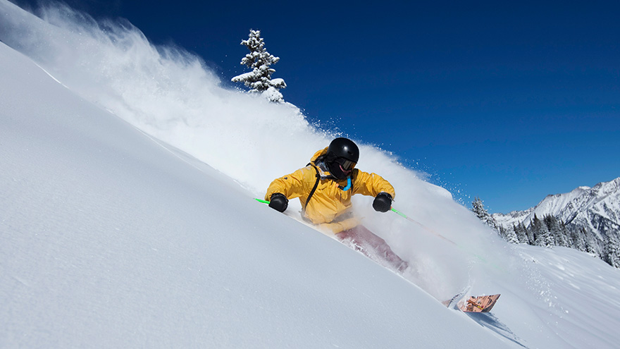 Man skiing down snow-laden mountain