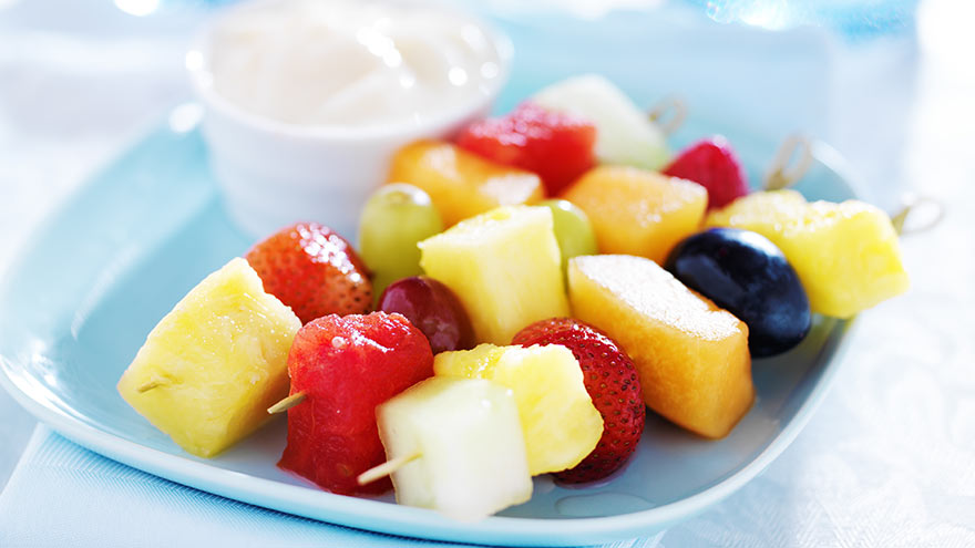 Children's fruit kabob with dip on blue plate