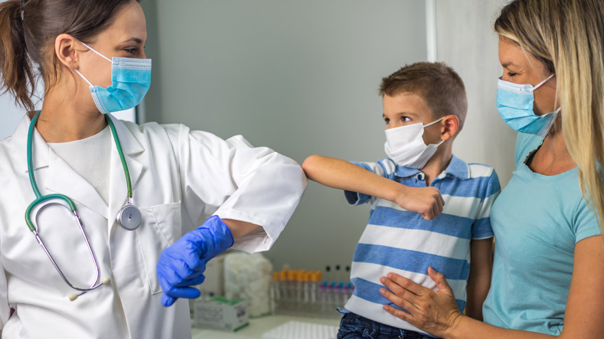 Médico y niño paciente chocando codos antes de la vacuna contra la gripe