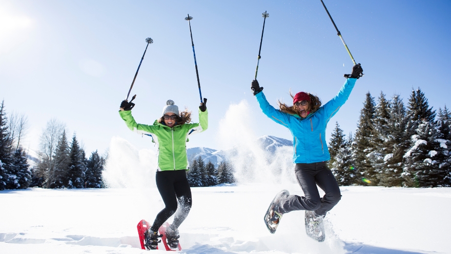 Women having fun snowshoeing