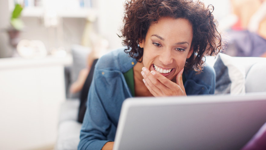 Mujer joven que reservando una cita en línea desde su computadora portátil