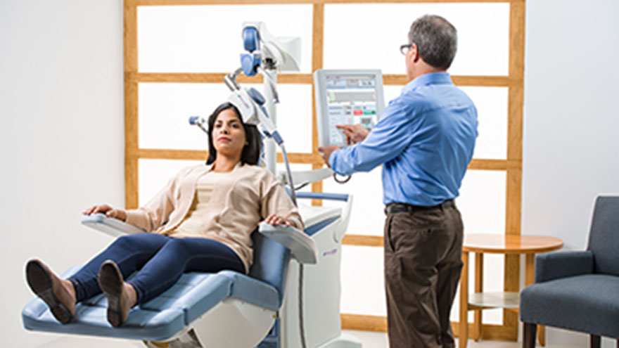 woman in doctors chair receiving tms therapy