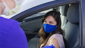 Mujer que recibe la vacuna a través de la ventanilla del automóvil